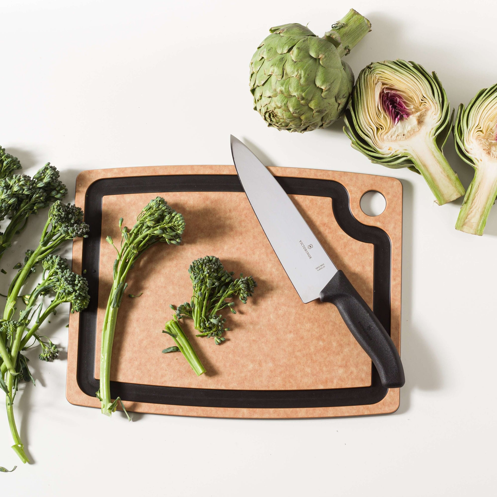 Epicurean Gourmet Series Cutting Board in Natural slicing up brocolinis and artichokes with a Victorinox Swiss Classic Chef's Knife 