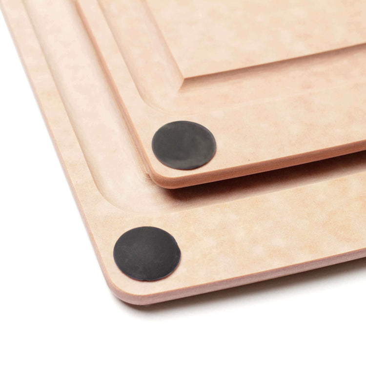 Up close detail of the All-in-One Cutting Board Set in Natural features the juice groove and non-slip feet