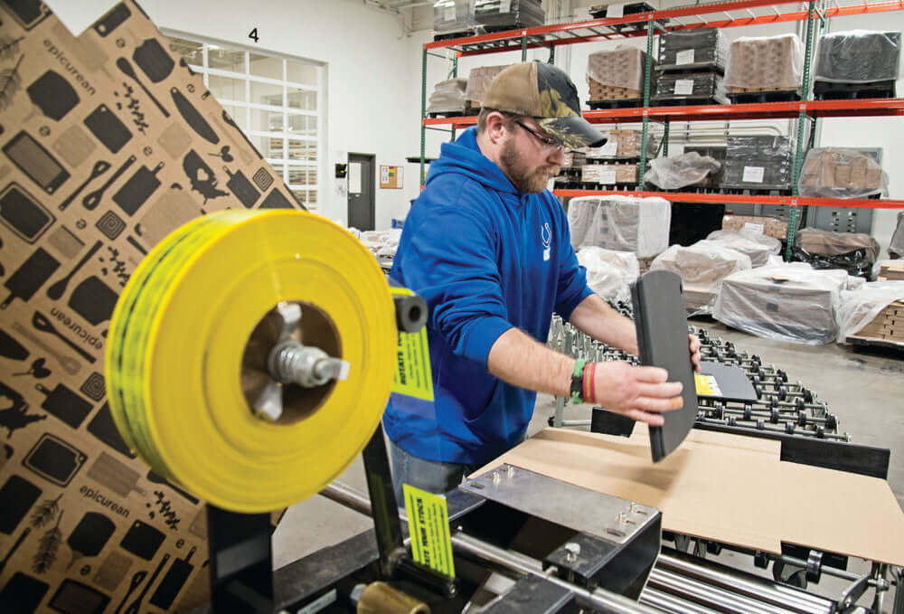 Epicurean Employee boxing up product and getting it ready to ship to our customers