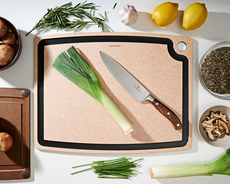Gourmet Series Cutting Board in Natural with a Victorinox Chef's Knife Preparing To Cut Assorted Vegetables