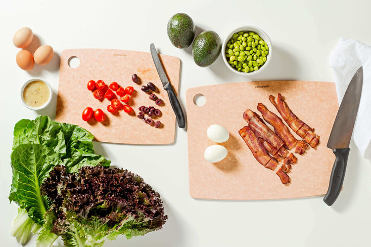 Epicuren Kitchen Series Cutting Board Set in Natural sizes 14.5 inches by 11.25 inches and 11.5 inches by 9 inches ready to support your culinary adventures by slicing assorted vegetables and proteins.