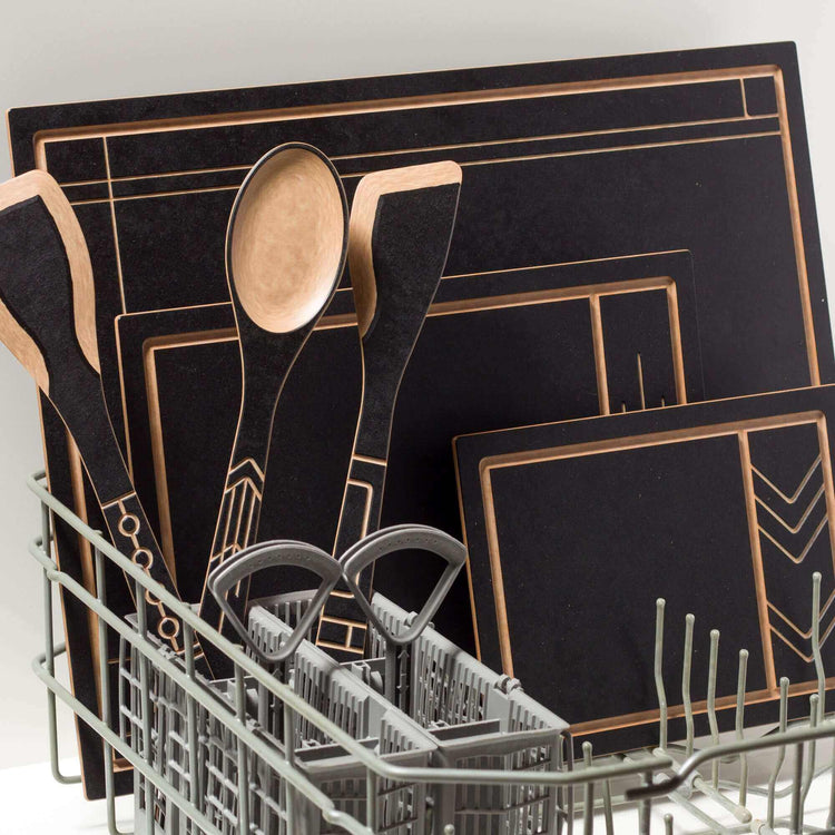 The Frank Lloyd Wright Collection featuring Cut and Serve Small, Medium and Large Boards, Saute Tool, Large Spoon & Paddle in Slate/Natural placed in the dishwasher 