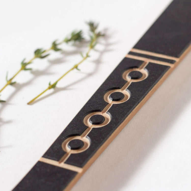 The Frank Lloyd Wright Utensil Set includes the Large Spoon, Paddle and Sauté Tool in Slate/Natural this is a close up image of the paddle design