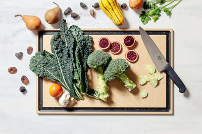 Epicurean Chef Series in Natural with sliced vegetables and a Victorinox Chef's Knife