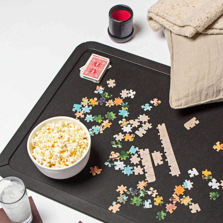 Epicurean Board Game Board in Large Slate Ready For Game Night with colorful assorted puzzle pieces, popcorn and a deck of cards