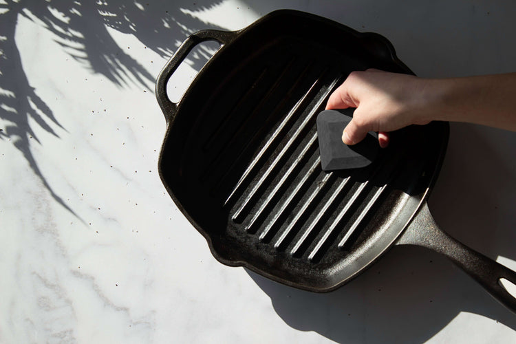 Epicurean Pan Scraper in Slate being used to clean a cast iron skillet